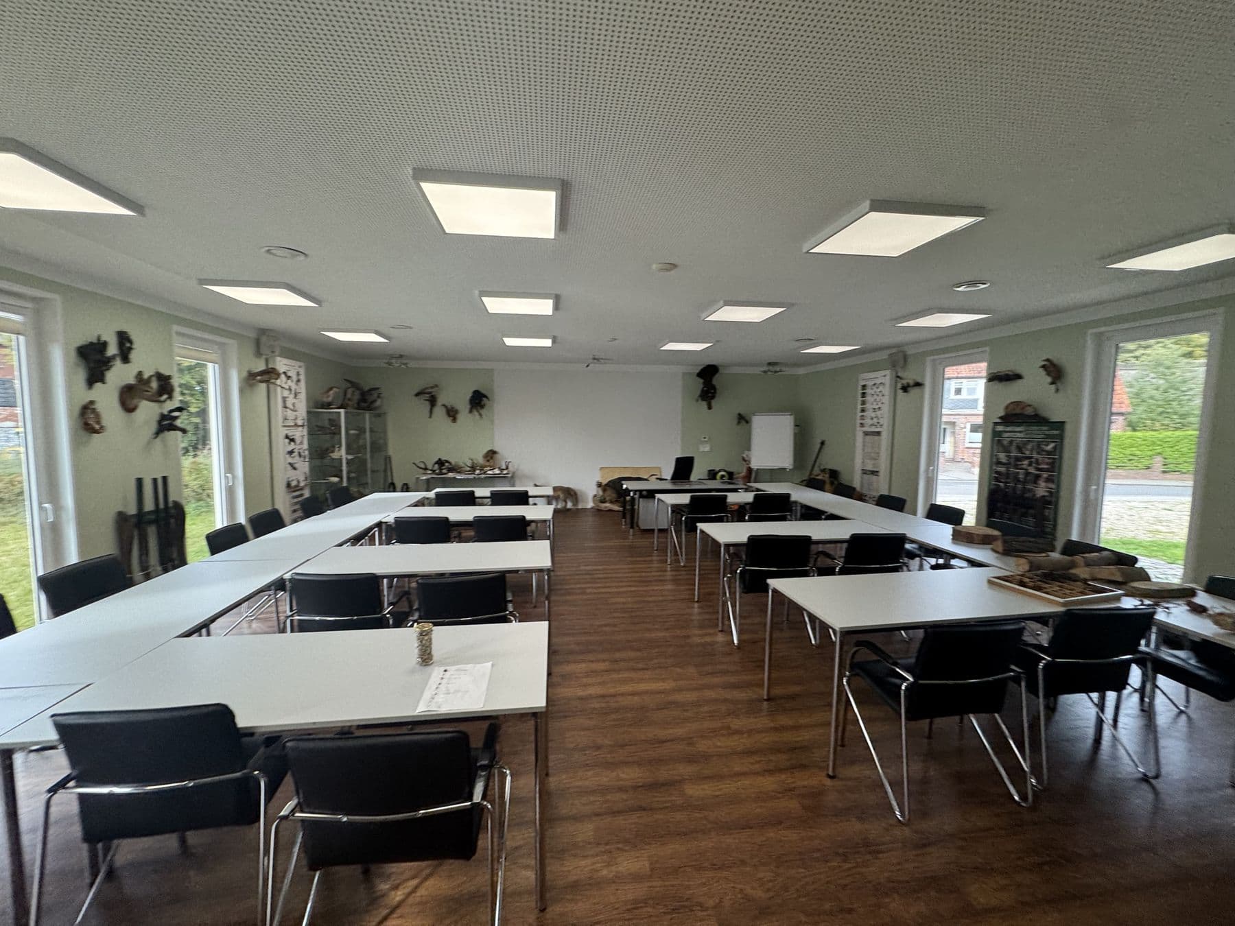 Seminarraum mit weißen Tischen in U-Form und Präparaten an den Wänden